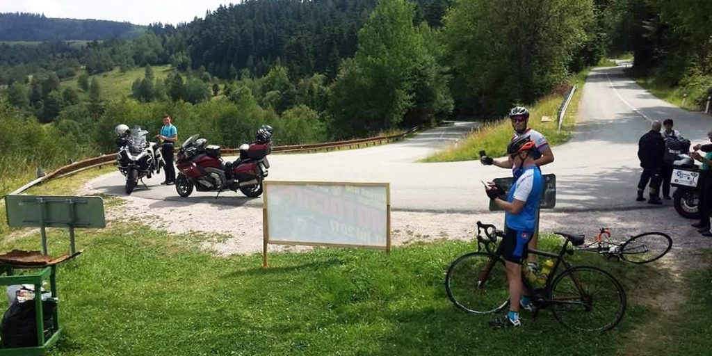Magyarországi túra: Kerékpárosok és motorosok pihennek egy erdei útkereszteződésnél, a zöld dombokat csodálva, túra közben. Tekeregj.hu
