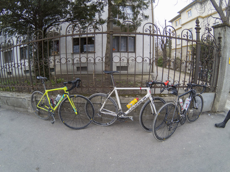 Magyarországi túra: Három kerékpár lakatolva egy díszes kerítéshez hegyi túra közben, lakóház és fák mellett, városi környezetben. Tekeregj.hu