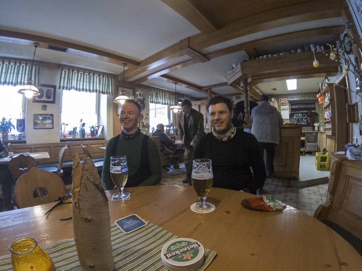 Magyarországi túra: Hegyi túra után két ember sörrel pihen egy hangulatos, fából épült pubban; kalandos kirándulás élményei. Tekeregj.hu