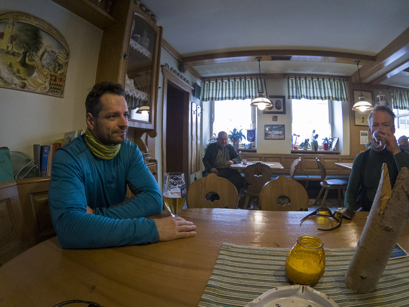 Magyarországi túra: Két bukósisakos kerékpáros kültéri térképet néz, egyikük útvonalat mutat hegyi túrához, felhős ég alatt. Tekeregj.hu