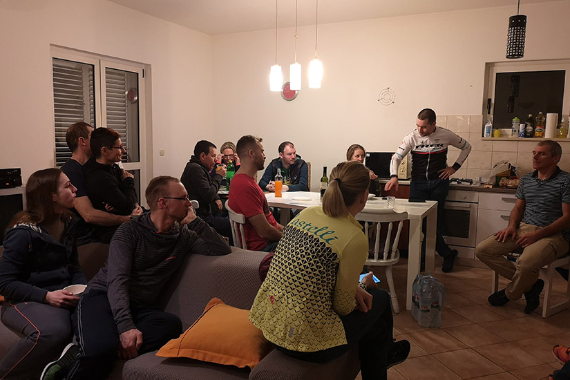 Magyarországi túra: Baráti társaság gyalogtúra és kirándulás élményeit meséli egymásnak egy hangulatosan megvilágított nappaliban. Tekeregj.hu