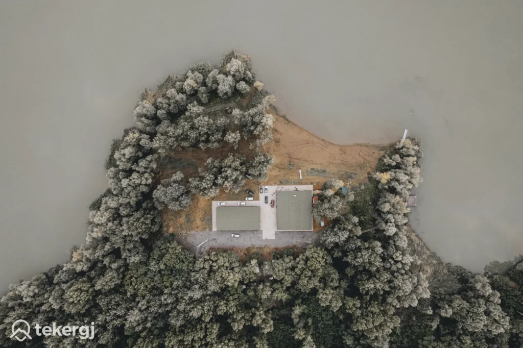 Magyarországi túra: Légi felvétel: fás félsziget vízben, két épület, betonpart. Ideális bringa- vagy túraútvonal gyönyörű panorámával. Tekeregj.hu