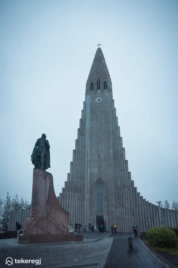 Magyarországi túra: Hallgrímskirkja templom, Reykjavík, Izland - kirándulók gyülekeznek Leif Erikson szobra előtt, borús ég alatt. Tekeregj.hu