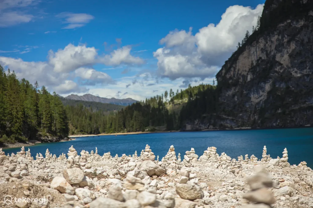 Magyarországi túra: A Lago di Braies kristálytiszta tava, sziklás partján álló kőtoronnyal, erdős dombok és a Dolomitok – ideális hely kerékpáros vagy gyalogos túrákhoz. Tekeregj.hu