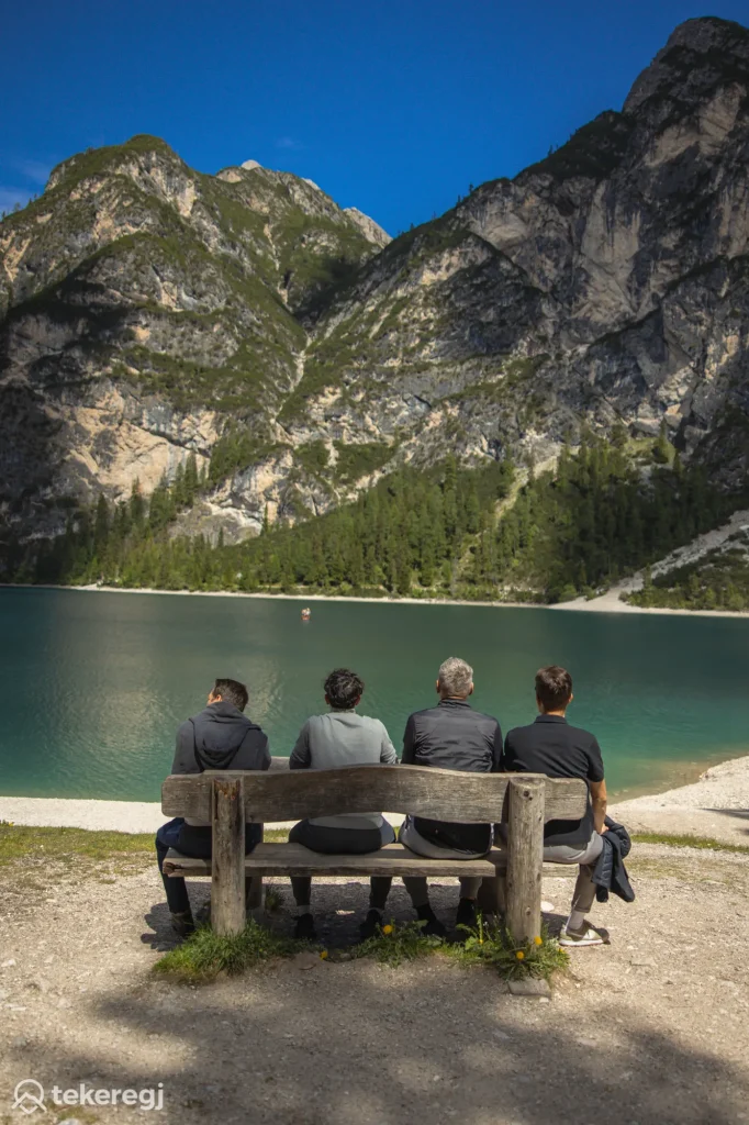 Magyarországi túra: Négy kiránduló a Lago di Braies tó partján, a háttérben a Dolomitok hegyei – ideális hely egy tókerülő túrához. Tekeregj.hu
